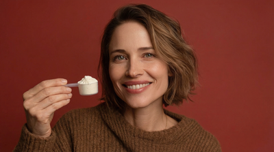 Woman smiling up close holding a scoop of Monna Super Collagen powder feeling confident and happy